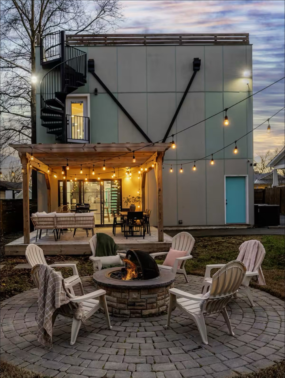 Outdoor patio with fire pit and string lights for a short-term rental